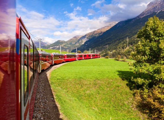 A train travels round a curved track in summer