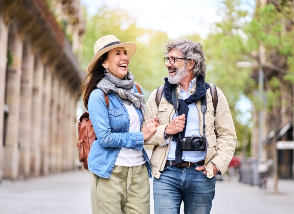 Happy older couple having fun walking outdoors in city.
