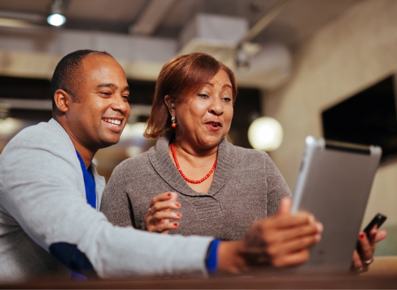 two people holding computer tablet talking