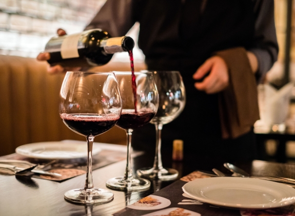Red wine pouring into wine glass, close-up