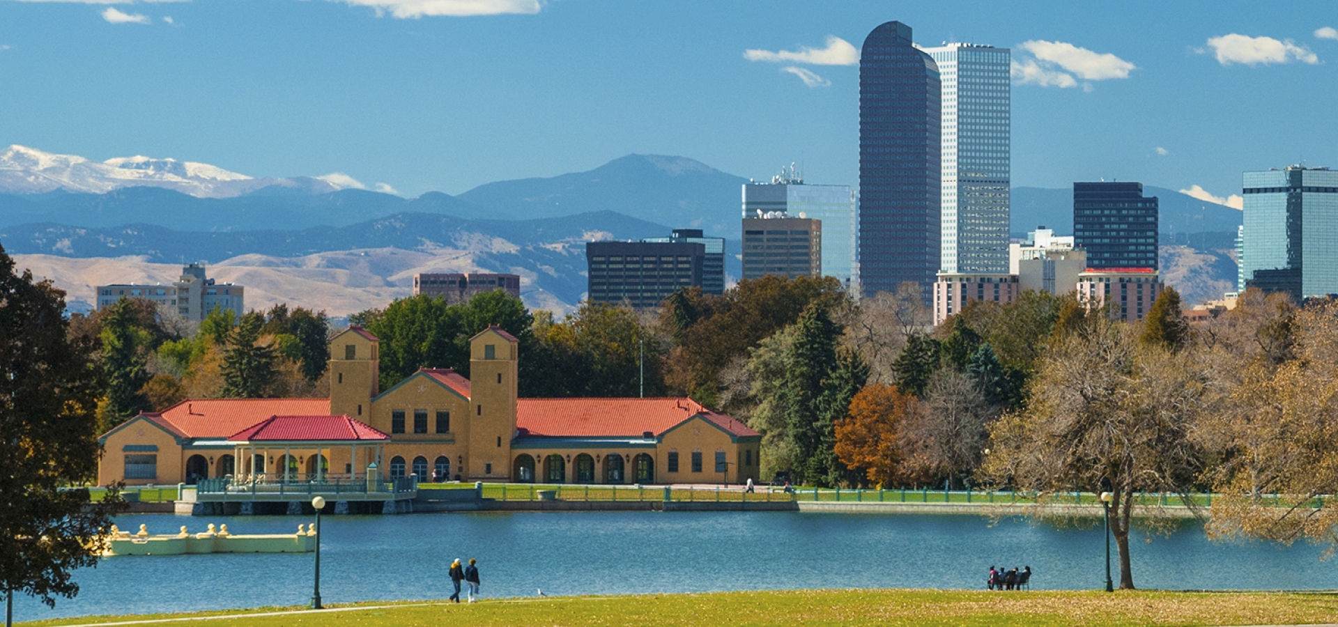 Denver skyline, clouds, mountains, and City Park with a lake