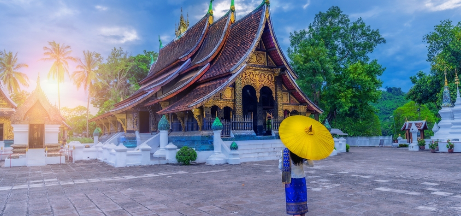 Asian woman wearing a Lao national costume visits Wat Xieng Thong in Luang Prabang, Laos