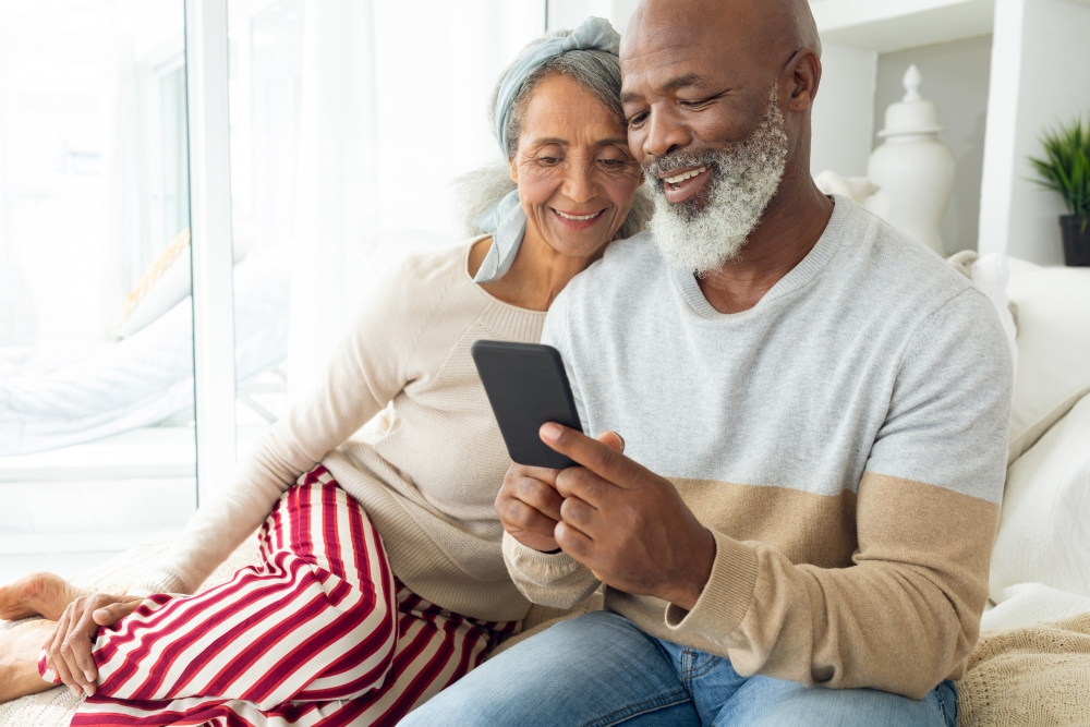 happy retired couple looking at cell phone